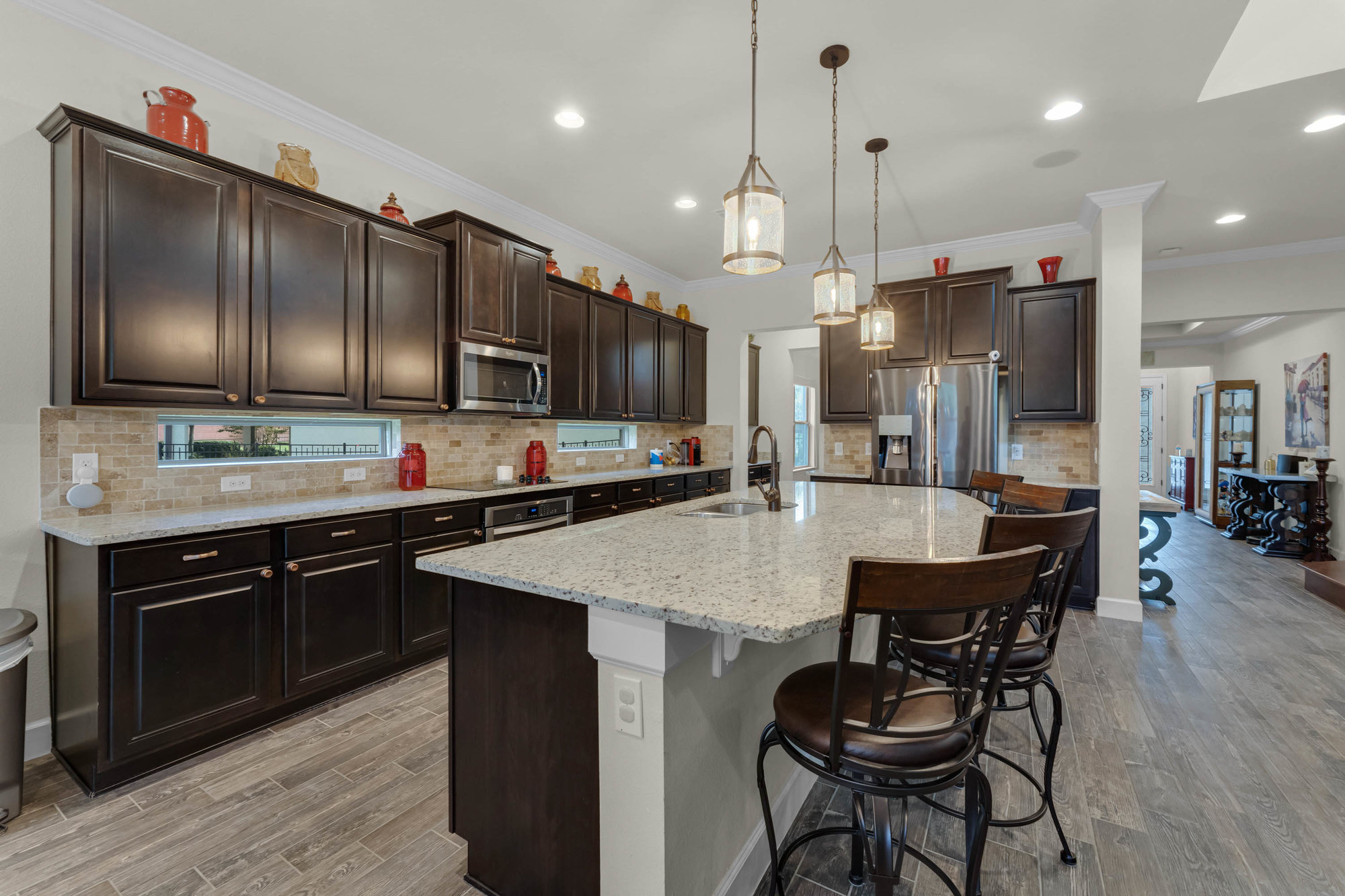 kitchen with dark brown cabinetry and large marble island